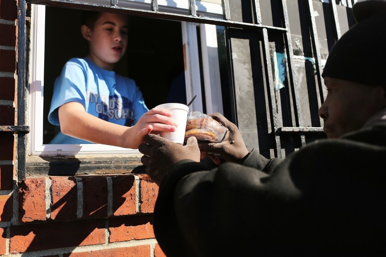 A youth volunteer serves food to the needy at Cathedral Hall in Camden, N.J., Oct. 11. Cathedral Hall serves lunch five days a week to thousands of Camden residents having trouble affording food.