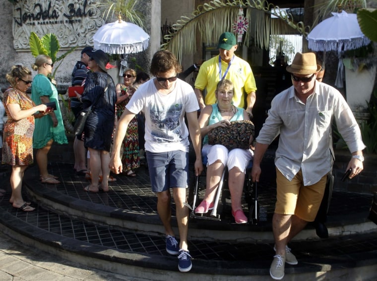 A survivor of the bomb blast is helped by her family as they arrive for the commemoration service for the 10th anniversary of the Bali bombing.