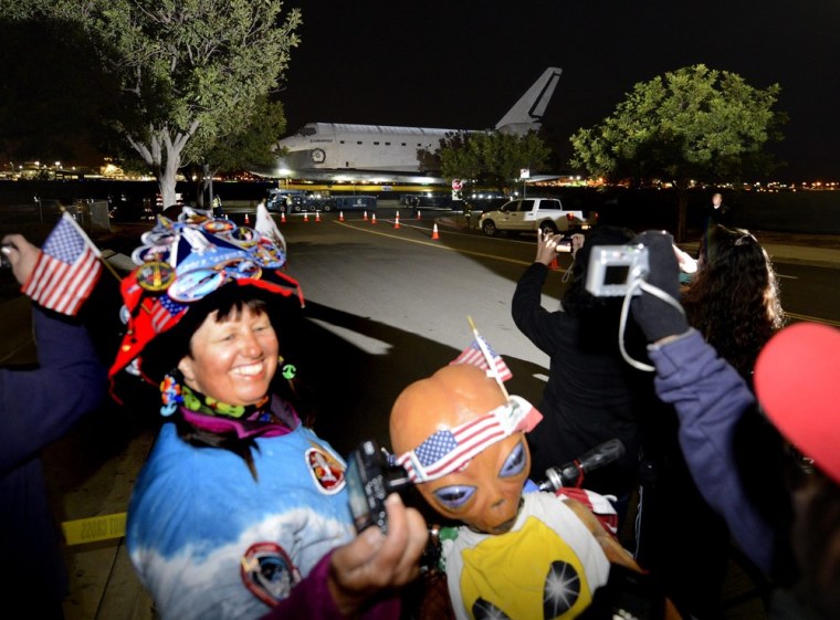 Vivian Robinson and her alien doll joined hundreds of spectators to watch the Space Shuttle Endeavour leave Los Angeles airport on its journey through the streets of Los Angeles on October 12, 2012. The trip to the California Science Center will take two full days to complete.