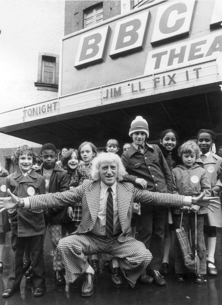English disc jockey, television broadcaster and charity worker Jimmy Savile on April 17, 1974, with some of the children who were going to take part in his