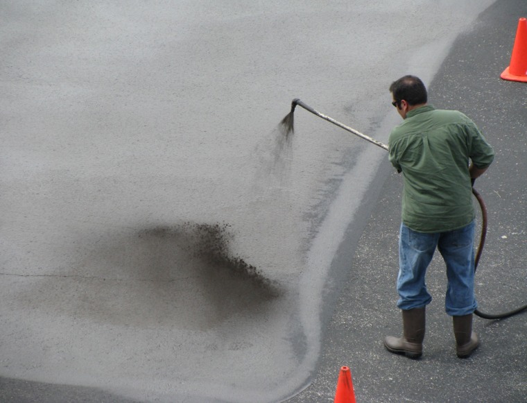 Coal tar sealant is applied at a study site at the University of Texas in Austin.