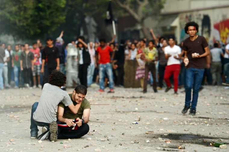 An anti-Muslim Brotherhood and President Mohamed Morsi protester cries on the ground as a man tries to calm him down during clashes with Morsi supporters in Tahrir square, in Cairo, on Oct. 12, in the worst violence over Egypt's new Islamist leader, a day after he crossed swords with the judiciary. The health ministry said at least 12 people were wounded as protesters showered each other with stones, after Morsi supporters tore down a podium from which anti-Brotherhood chants were being orchestrated.
