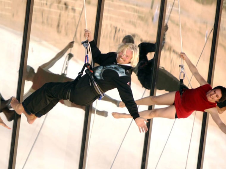 Virgin Galactic founder Richard Branson joins in on the acrobatics performed by the Project Bandaloop dance troupe during the dedication of Spaceport America's terminal/hangar facility.