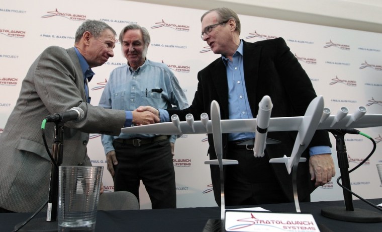 Microsoft co-founder Paul Allen, right, shakes hands with former NASA Administrator Mike Griffin as aerospace pioneer Burt Rutan looks on, following a Seattle news conference to announce the creation of Stratolaunch Systems.