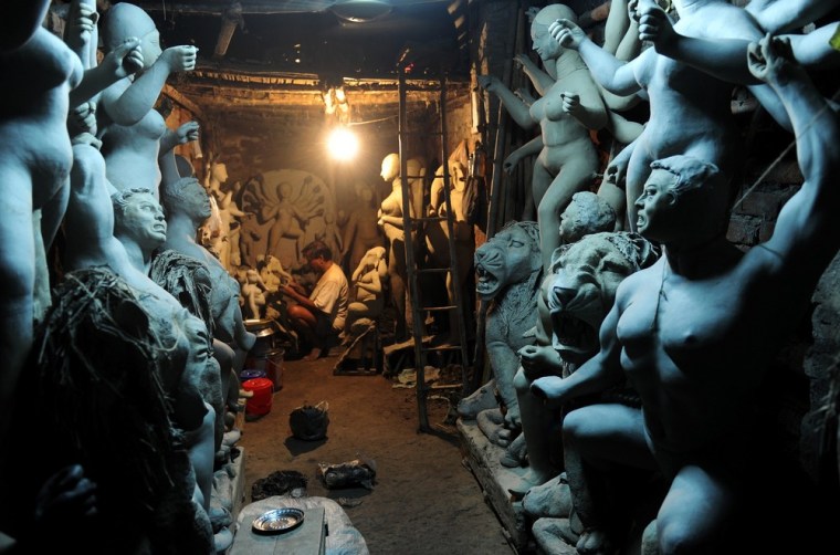 An artisan works on semi-finished clay statues of Hindu deities in Kumartoli, the idol-makers' village of Kolkata, India, on August 22.