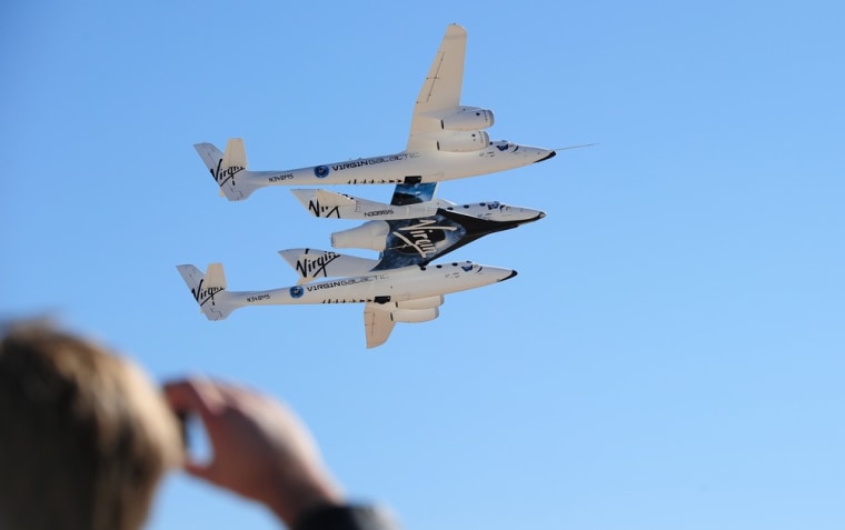 Virgin Galactic's WhiteKnightTwo carrier plane flies over Spaceport America in New Mexico with the SpaceShipTwo rocket plane nestled between its twin fuselages.