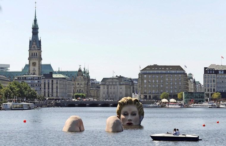 A boat passes a sculpture of a giant mermaid designed by German artist Oliver Voss on the river Alster in Hamburg, northern Germany, on Tuesday. The sculpture made of styrofoam and steel will be on exhibit for ten days.