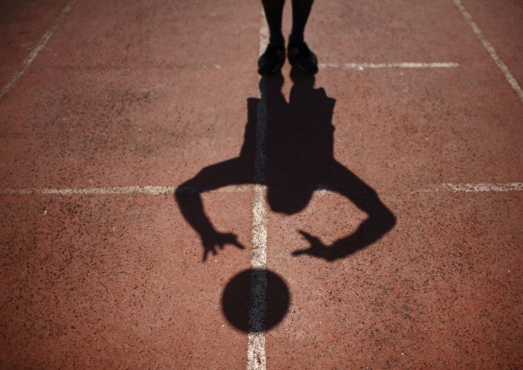 The shadow of a player casts on the ground while practicing volleyball during the opening ceremony of the first South Asia LGBT Sports Festival in Kathmandu, Nepal, Oct. 12.