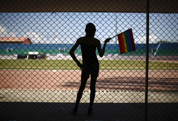A reveler holds the gay pride flag during the opening ceremony of the first South Asia Lesbian, Gay, Bisexual and Transgender, LGBT, Sports Festival in Kathmandu, October 12, 2012. The three-day long event is organized by the Blue Diamond Society, a LGBT rights group, to promote the equality, rights and social justice of LGBT through sports, according to Sunil Babu Pant, managing director of BDS.