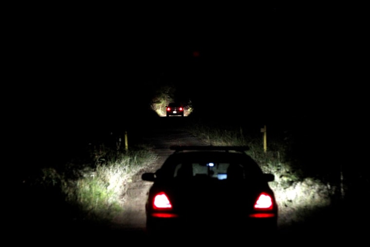 Officers drive on Parker Boulevard off State Road 24 near Cedar Key, Fla., on Friday, after a body that may be missing University of Florida student Christian Aguilar was found.