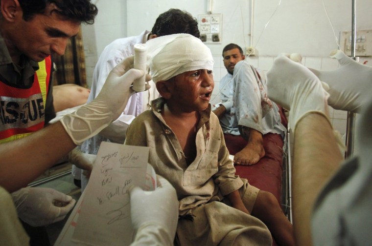Paramedics and a rescue worker attend to a child who was wounded in a suicide bomb attack in Pakistan.