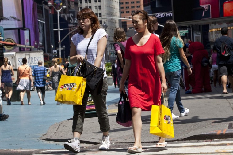 Women carry shopping bags through Times Square in New York. U.S. retail sales rose in September as Americans bought more cars and gasoline.