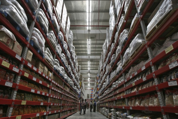 Workers walk inside an aisle of the newly opened Bharti Wal-Mart Best Price Modern wholesale store.