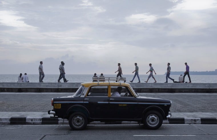 A driver waits for customers on Marine Drive in Mumbai on October 2, 2012.