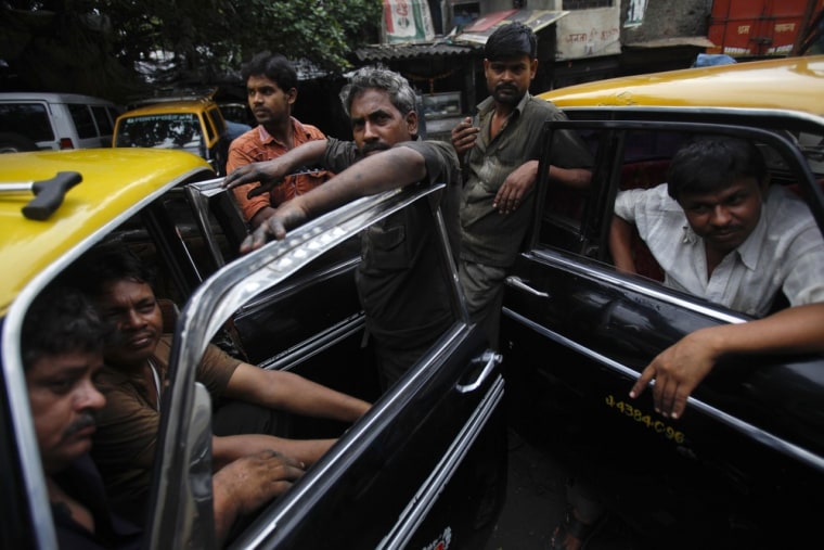 Drivers and mechanics of Premier Padmini taxis gather together at a workshop in Mumbai, India on October 4, 2012. The Premier Padmini was manufactured in India by Premier Automobiles from 1964 to 2000 and is based on the design of Fiat's 1100-series cars from the 1960s. The vehicle quickly became the iconic workhorse in Mumbai's fleet of black and yellow taxis until economic liberalisation in the 1990s allowed different makes and models to be produced in India.