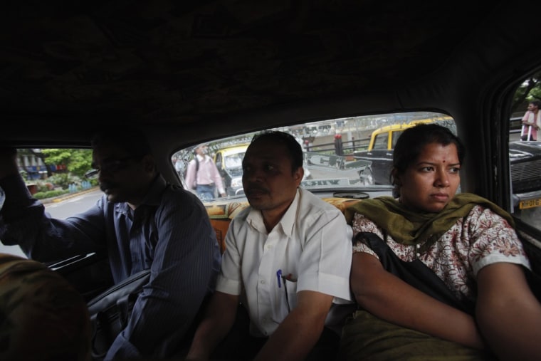 Customers sit in the cramped back seat of a Premier Padmini taxi during rush hour in Mumbai on October 4, 2012.