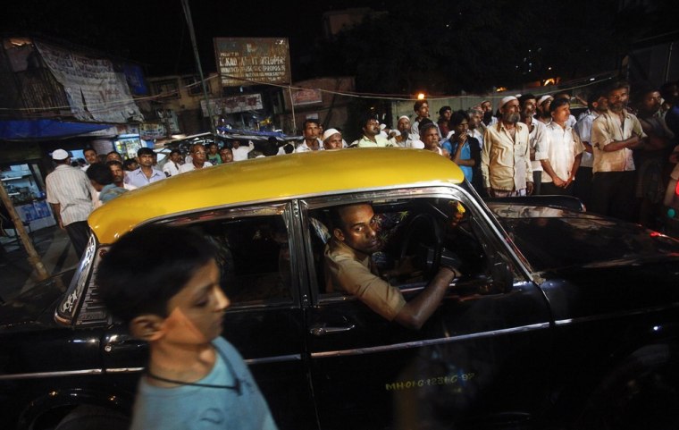 A taxi driver looks out of his Premier Padmini while stuck in traffic in a slum in Mumbai on October 3, 2012.