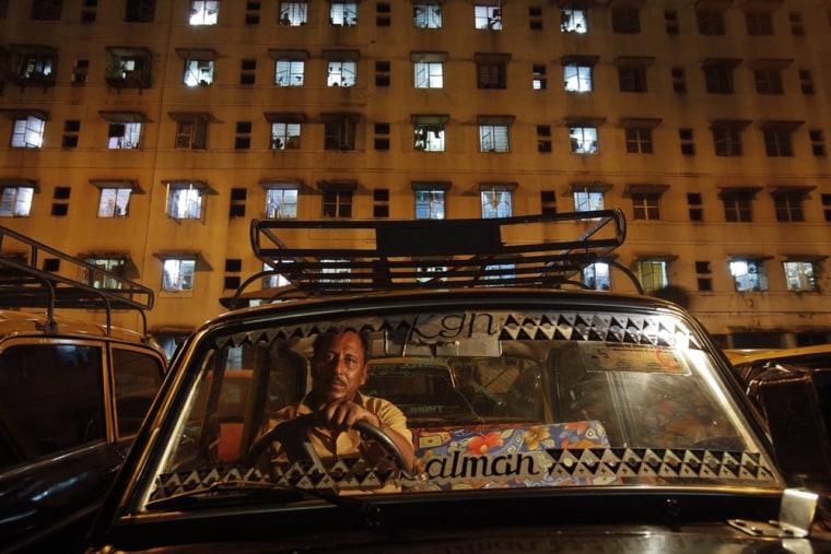 A driver waits for customers in front of an apartment building in Mumbai's suburbs on October 3, 2012.