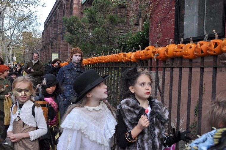 Pumpkins on the stakes of an iron fence light up this street in Cobble Hill, Brooklyn every Halloween. They're left up to deteriorate over time.