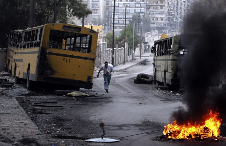 A man runs past a damaged bus at the front line between the Free Syrian Army and the pro-government forces in Aleppo on Wednesday.