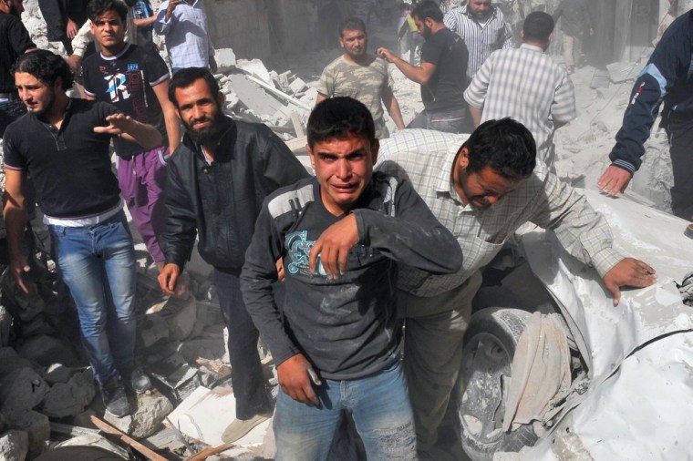 Syrian men react following an airstrike by government forces in Maaret al-Numaan on Oct. 18.