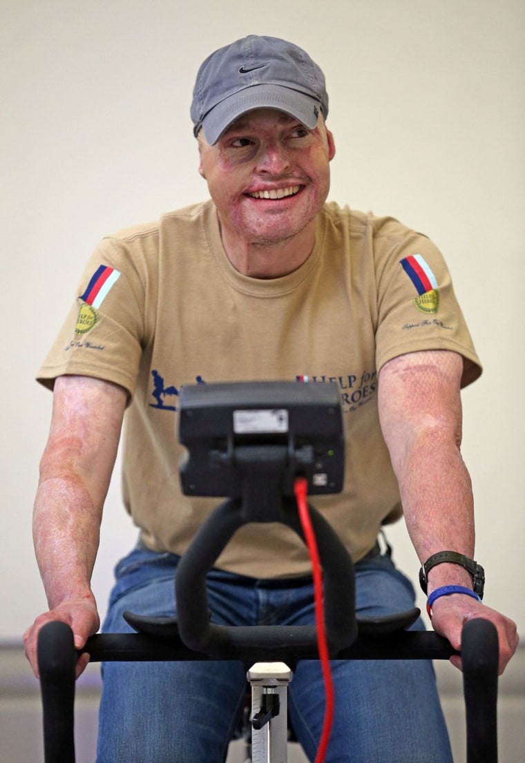 A injured serviceman laughs as he uses a exercise bike in the new Help for Heroes' Tedworth House rehabilitation center.