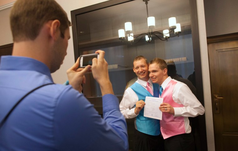 Mark Massey, center, and Dale Frost, right, pose for a picture after registering their marriage at the City Clerk's Office in New York on Oct. 11. New York is one of six states where same-sex marriage is legal.