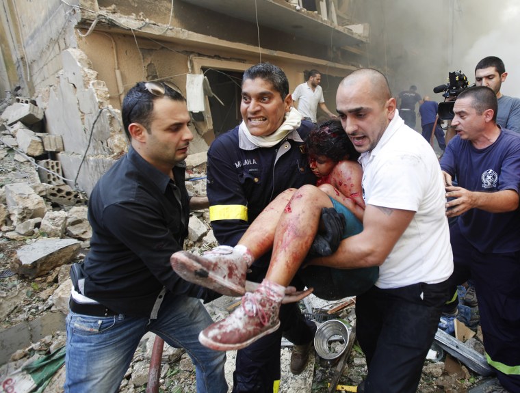Lebanese rescue workers and civilians carry an injured girl from the scene of an explosion in the mostly Christian neighborhood of Achrafiyeh, Beirut, Lebanon, on Oct. 19.