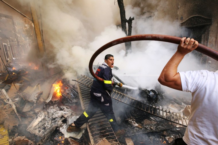 Firefighters extinguish fire at the scene of an explosion in Ashrafieh, central Beirut on Oct. 19.