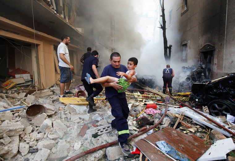 A Lebanese rescue man, carries an injured boy at the scene of an explosion in the mostly Christian neighborhood of Achrafiyeh, Beirut, Lebanon, on Oct. 19.