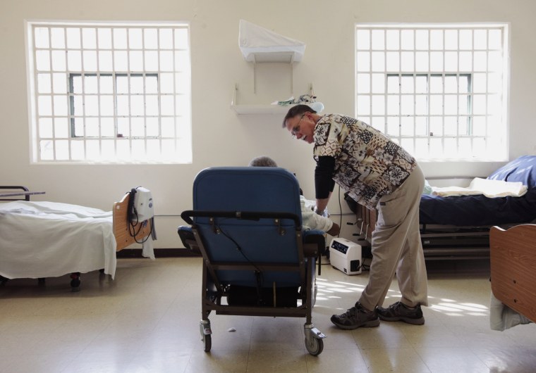 Dr. Davis Mathis visits with an inmate in the hospital unit at the California Medical Facility in Vacaville, Calif., Sept. 1.