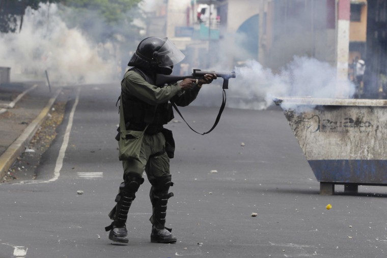 A riot policeman fires tear gas during a protest against a new legislation, which allows for the sale of land in Panama's free trade zone of Colon, in Colon City, Panama, Oct. 19, 2012. According to local media, hundreds of demonstrators protested against draft law No. 529, blocking roads and burning tires in the city, claiming that selling the land will affect their jobs and revenue which the Colon free trade zone, one of the largest free ports in the Americas.