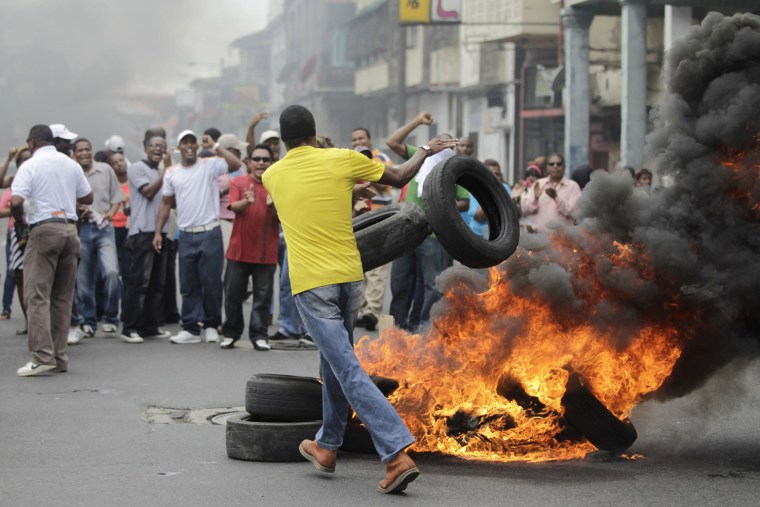 A demonstrator burns tires to block a road during a protest in Colon City, Panama, Oct. 19.