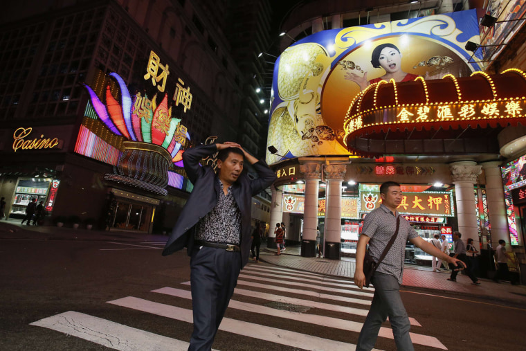 Mainland Chinese visitors walk past casinos in Macau, Oct. 10. One third the size of Manhattan, Macau ranks as the most densely populated place in the world. Last year it welcomed 28 million visitors, or more than the population of Australia.