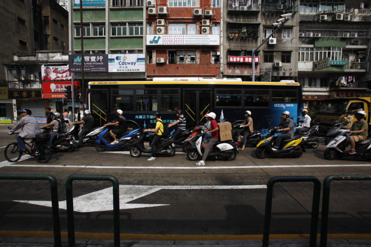Drivers and motorcyclists stop in front of a traffic light on Avenida de Horta e Costa, a main street in Macau's residential district, Oct. 11.