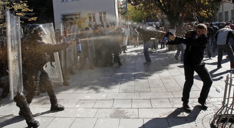 A Kosovo police officer and a protester spray each other with pepper spray, during a protest in the Kosovo capital Pristina on Monday, Oct. 22. Kosovo police in riot gear fired tear gas and used batons to disperse dozens of ethnic Albanians protesting a meeting between Prime Minister Hashim Thaci and Serbian leader Ivica Dacic. Protest early Monday was called by Self-Determination, a hardline opposition group that opposes any talks with Serbia.