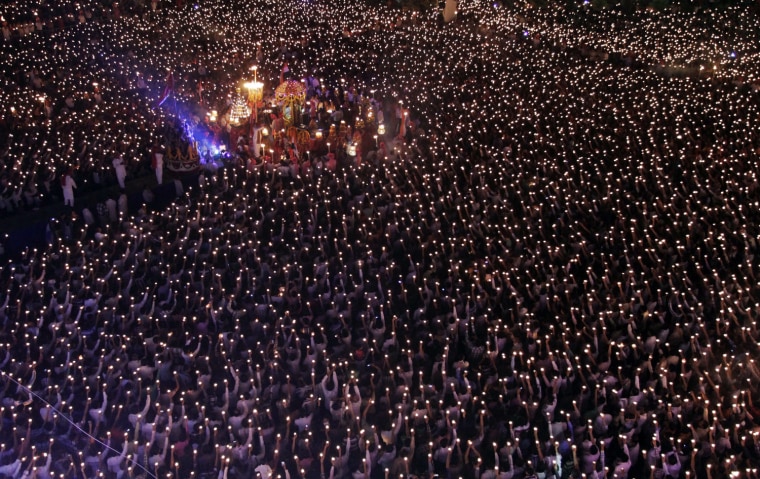 Indian devotees hold earthen lamps as they take part in the Maha Aarti ritual at Hindu deity Umiya Mata temple on the eighth night of Navratri or nine nights festival in Surat, about 275 kilometer South of Ahmadabad, India, Monday, Oct. 22. Every year thousands of devotees participate in this ritual.