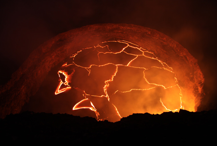 The lava lake casts red light at Kīlauea's summit at sunset. The lake is about 138 ft below the floor of Halemaʻumaʻu on Oct. 18.