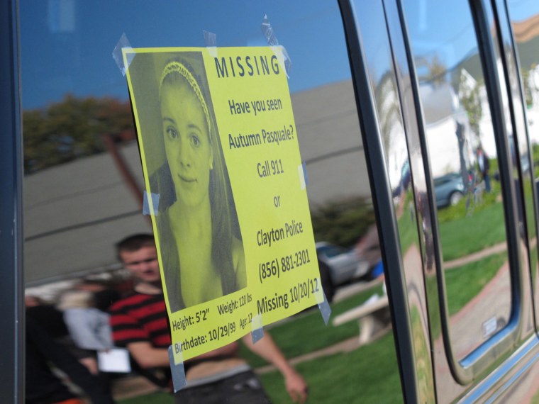 Volunteer searchers looking for a missing girl are reflected in the windows of a van with a flier about the disappearance on Oct. 22 in Clayton, N.J. Twelve-year-old Autumn Pasquale was last seen on Oct. 20.