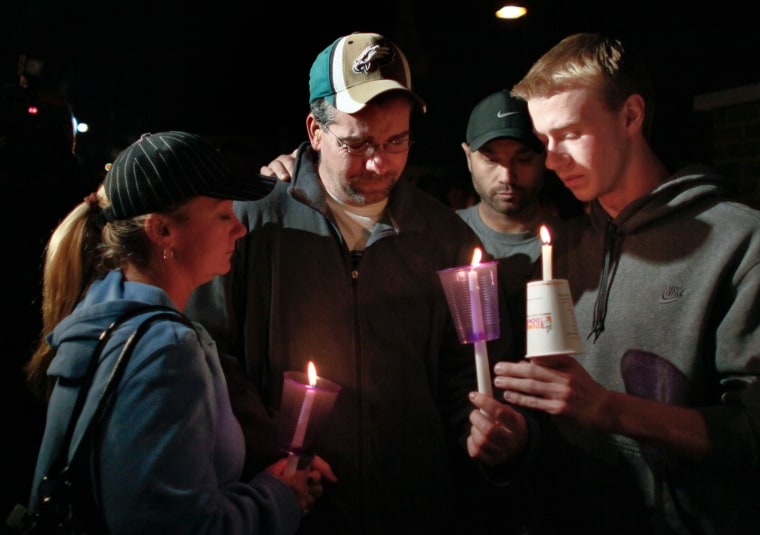 Anthony Pasquale, second from left, father of Autumn Pasquale, is comforted during a candlelight vigil for the missing girl, Oct. 22, in Clayton, N.J.