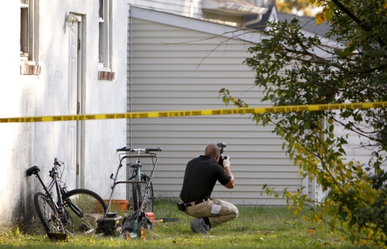 An investigators photographs evidence in the back yard of a house in Clayton, N.J. on Oct. 23, after the discovery of a girl's body in a home's recycling bin.