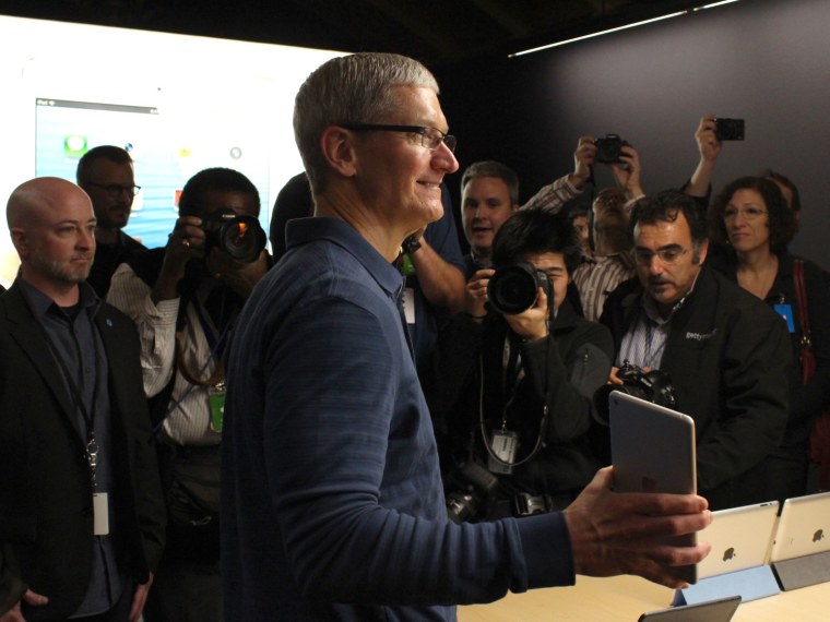 Apple CEO Tim Cook poses with an iPad Mini