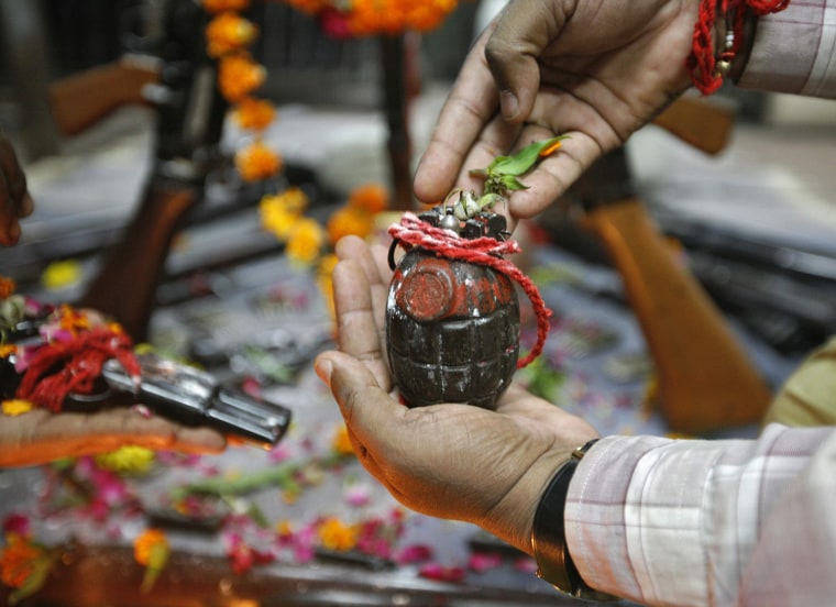 A police officer holds a hand grenade as he offers prayers in front of weapons, as part of a ritual for the Dussehra festival in the western Indian city of Ahmedabad Oct. 24. Dussehra is the Hindu festival which commemorates the triumph of Lord Rama over Ravana, marking the victory of good over evil.
