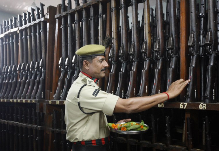 A policeman offers prayers in front of weapons as part of a ritual for the Dussehra festival in the western Indian city of Ahmedabad Oct. 24.