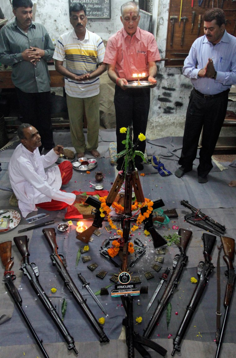 A priest chants as paramilitary Home Guards officers perform rituals on weapons at their headquarters on Vijayadashmi, or Dussehra festival, in Ahmadabad, India, Oct. 24.
