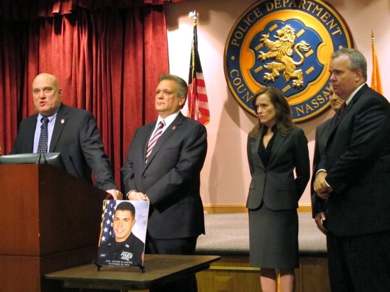 Nassau County PBA President James Carver, left, discusses the shooting death of Police Officer Arthur Lopez, shown in picture on table, at a news conference, on Tuesday at police headquarters in Mineola, N.Y. Listening from second left are Nassau County Executive Edward Mangano, District Attorney Kathleen Rice, County Comptroller George Maragos and First Deputy Police Commissioner Thomas Krumpter.