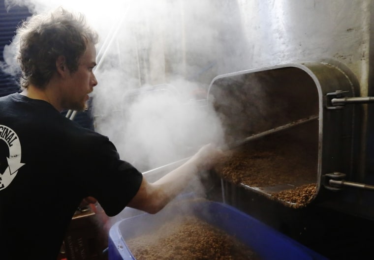 London: Brewer Chrigl Luthy cleans out the malt and spent grain from the mash tun used in the brewing process to create an India Pale Ale at The Kernel micro-brewery.