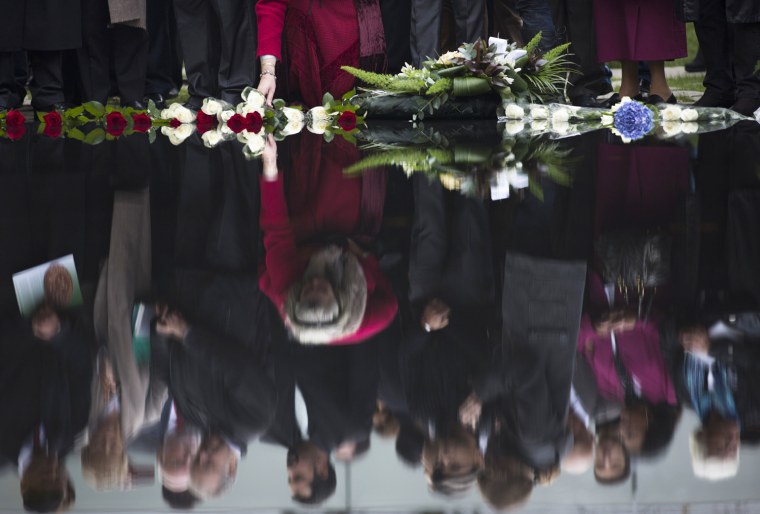 People lay flowers during the dedication of the memorial to the Sinti and Roma in Berlin, Germany, on Wednesday.