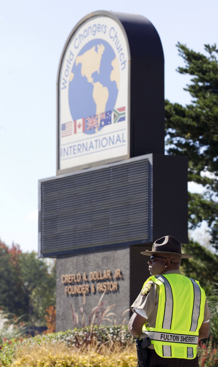 A Fulton County sheriff's deputy stands guard Wednesday outside the World Changers International church near College Park, Ga., after a fatal shooting inside.