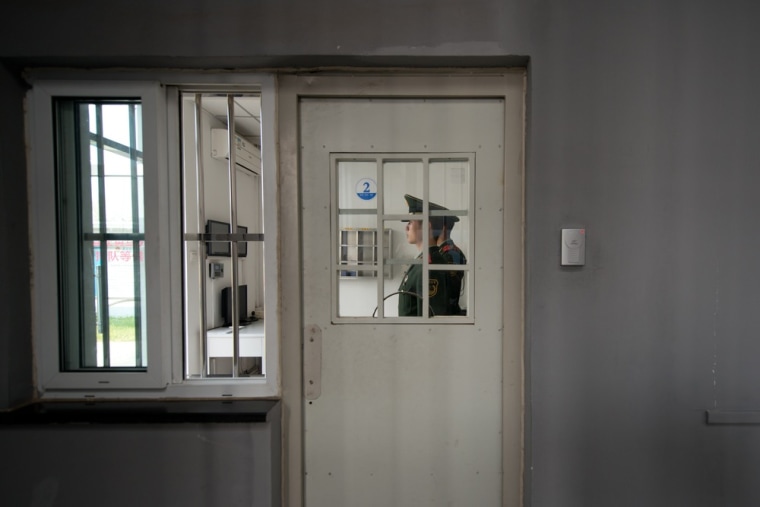 A paramilitary guard stands at a security door inside the No.1 Detention Center.